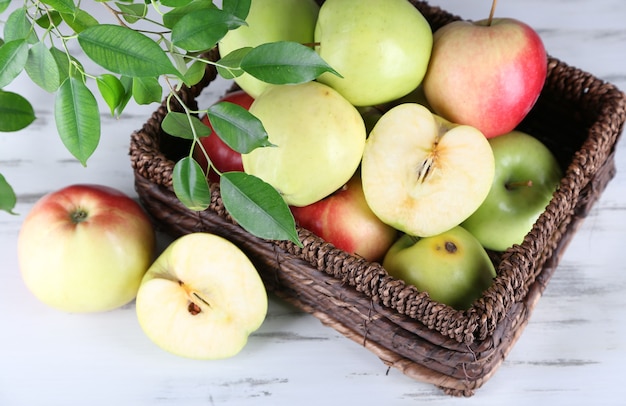 Juicy apples in basket on wooden table