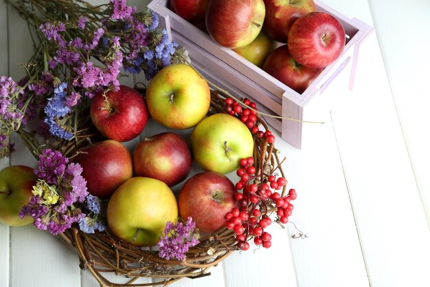 Juicy apples in box on white wooden table