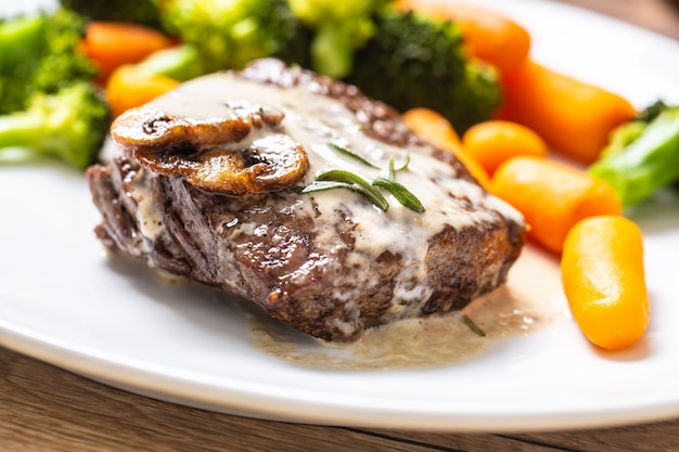 Juicy Beef Rib Eye Steak with mushroom sauce and baby vegetable.