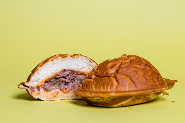 juicy burger cut with delicious filling on a yellow background