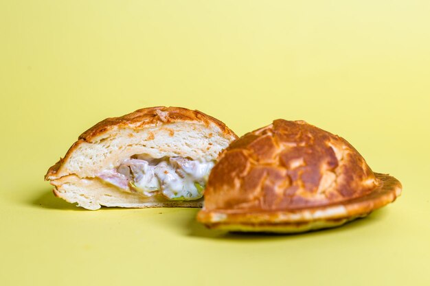 juicy burger cut with delicious filling on a yellow background