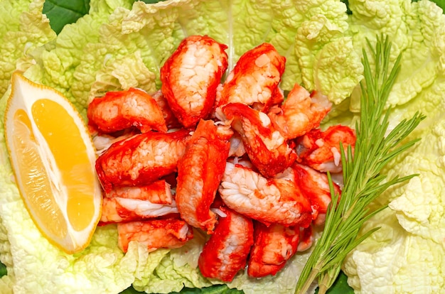 Juicy crab meat on green lettuce leaves with a slice of lemon