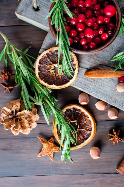 Juicy cranberries in a plate and spice on wood table