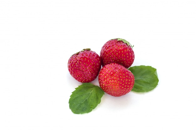 Juicy fresh strawberry with mint leaves isolated on a white background.