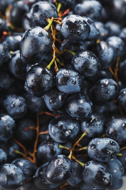 Juicy fruits of black ripe grapes close-up as texture.