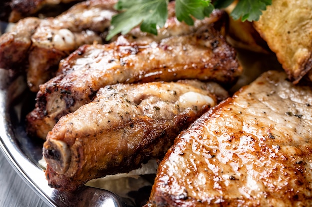 Juicy grilled meat pieces and herbs close up