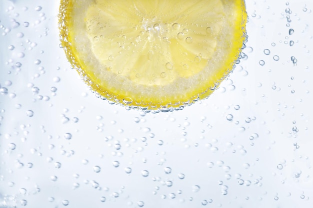 Photo juicy lemon slice in soda water closeup