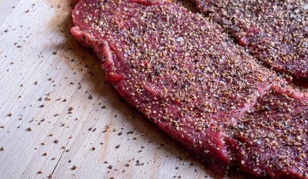 Juicy pepper steak with black red green ground pepper on a wooden table Cooking mediumroasted pepper steak