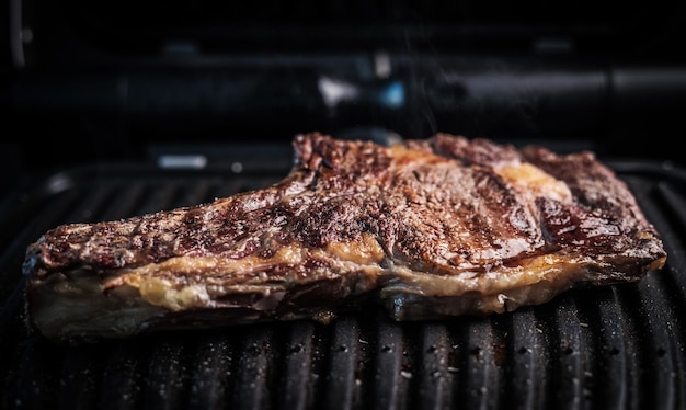 Juicy piece of beef steak on a grill seasoned with spices