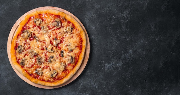 Juicy pizza with tomatoes mushrooms cheese and tomato sauce on a board on a dark background Vegetarian pizza Top view copy space