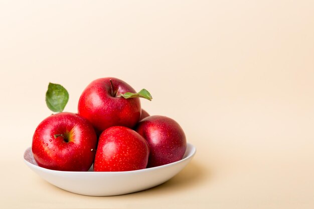 Juicy red apples in a bowl or plate on the table top view Copy space