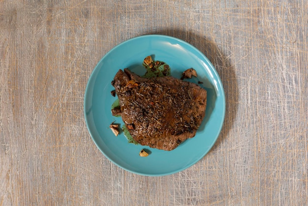 Juicy steak with blood fried in a pan top view traditional food