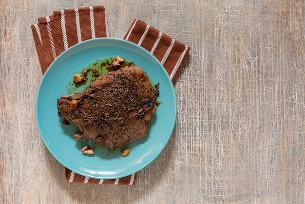 Juicy steak with blood fried in a pan top view traditional food