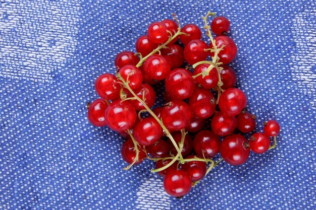 Juicy sweet red currant berries on a blue napkin Healthy food concept Closeup of sweet berries