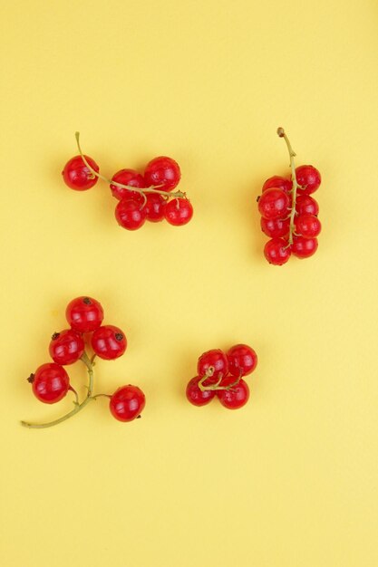 Juicy sweet red currant berries on a yellow background Healthy food concept Closeup of sweet berries