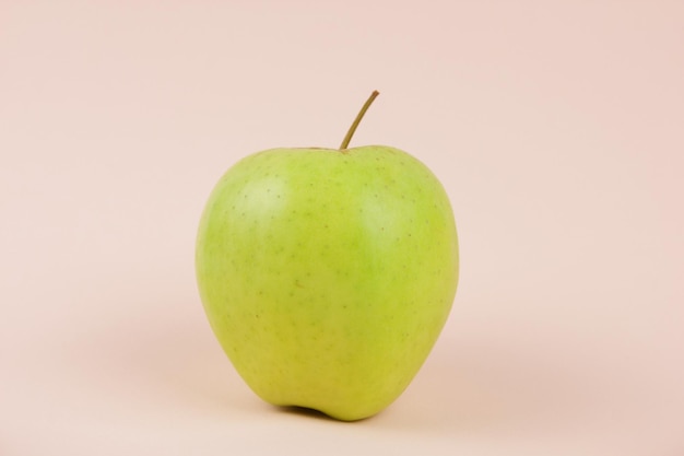 Juicy sweet whole apple on a pink background Healthy food concept Closeup of a sweet fruit