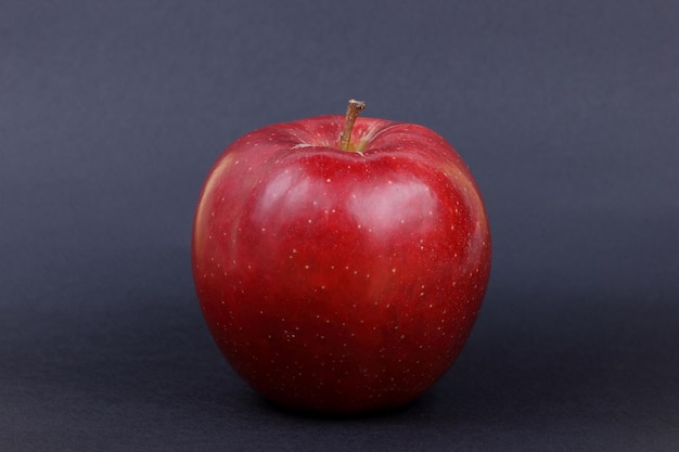 Juicy sweet whole red apple on a black background Healthy food concept Closeup of a red fruit