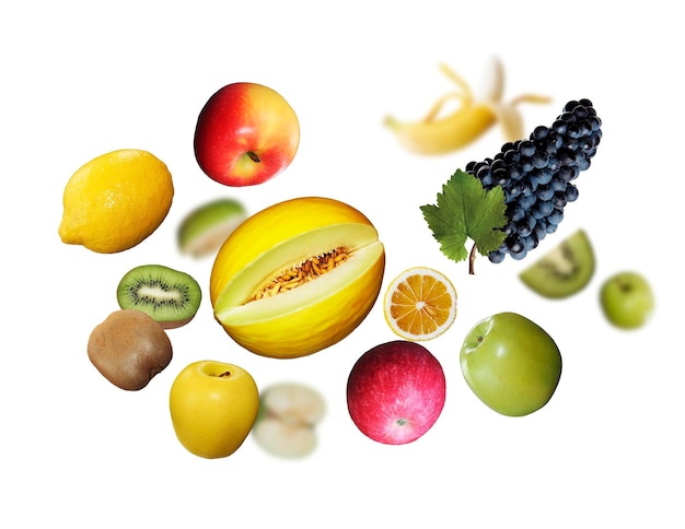 Juicy tasty fresh limons apple kiwi grapes levitate on a white background healthy diet Fresh fruits and vegetables