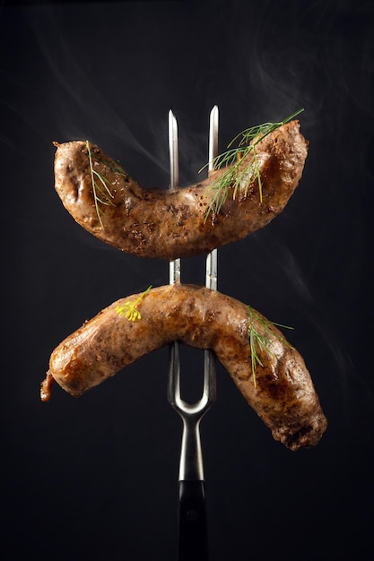 Juicy and tasty fried Bavarian sausages on a fork