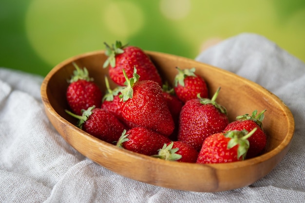 Juicy tasty ripe strawberries on a wooden plate top view Place for an inscription