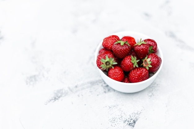 Juicy tasty strawberries in a white plate on the table