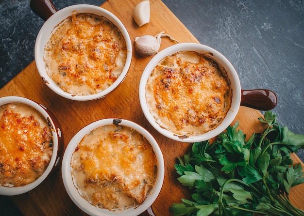 Julienne in portions, Mushrooms with cream and cheese, Restaurant food on a dark background