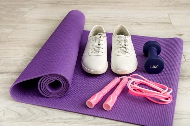 Jump rope sneakers dumbbells on a gymnastic mat