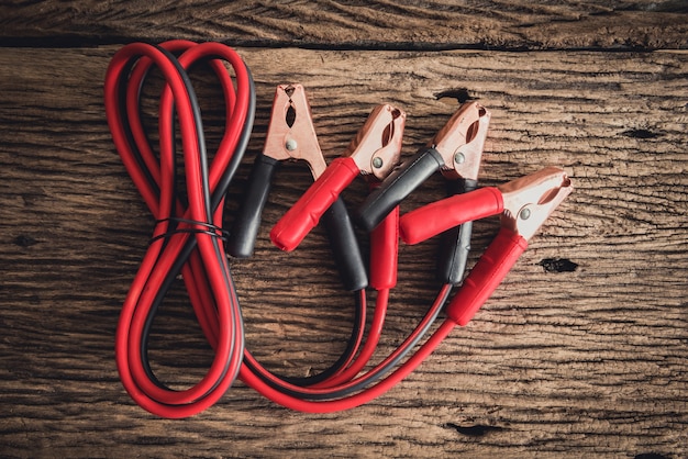 jumper cable for car battery on wooden background