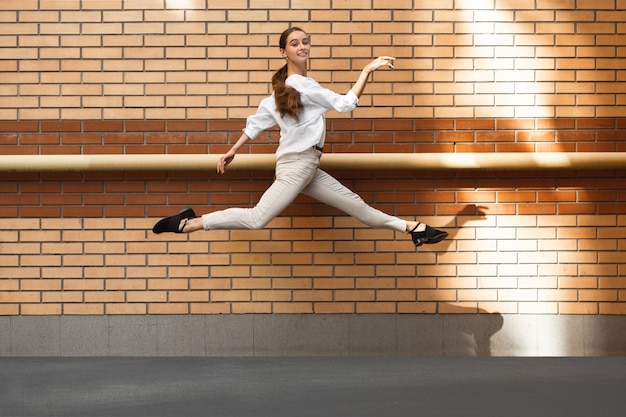 Jumping woman in the city, ballet dancer