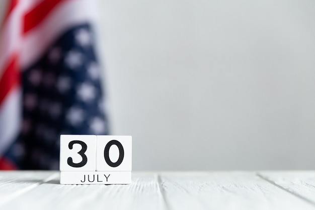 June day on wooden blocks with the US flag in the back