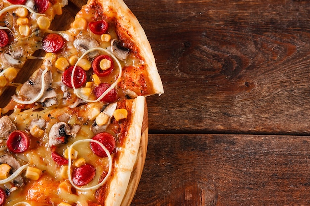 Junk food, unhealthy eating habits, Italian pizza on rustic wooden table, flat lay. Dark background with copy space.