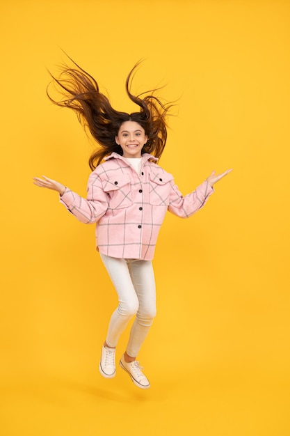 Just having fun express happiness happy childhood happy girl in pink checkered shirt hipster kid casual style jump high energetic tween child wear plaid shirt teen in chequered flannel jacket