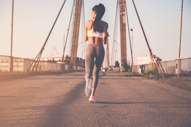 Just keep running. Full length rear view of beautiful young woman in sports clothing 