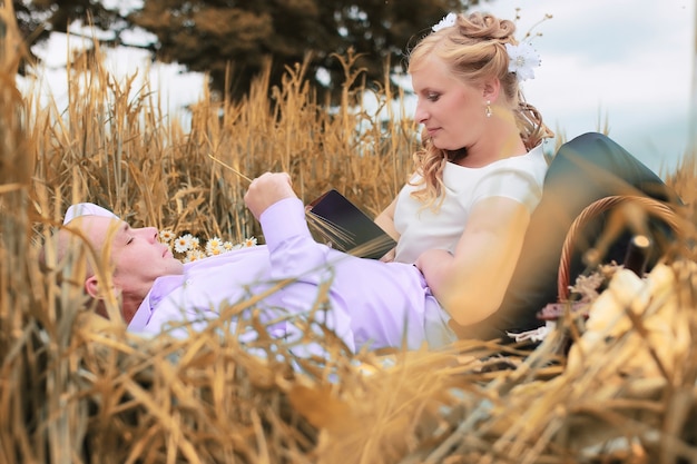 Just married lovers walking in a field in autumn day