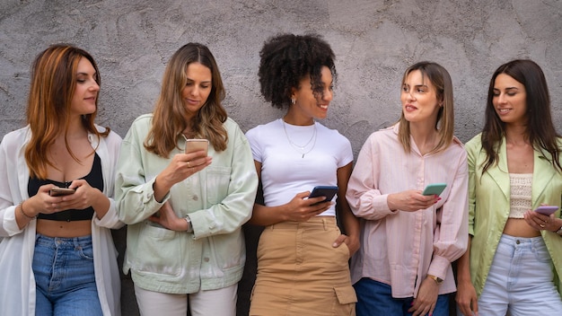 Just woman meeting with young girls holding smartphone and talking each other. Happy girls using technology concept.