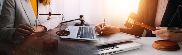 Justice and law conceptMale judge in a courtroom with the gavel working with computer and docking keyboard eyeglasses on table in morning light