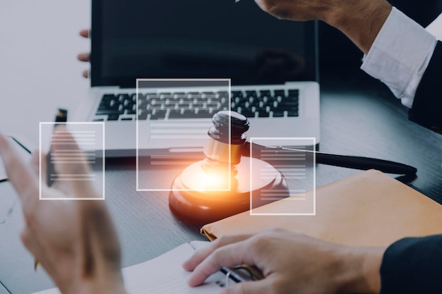 Justice and law conceptMale judge in a courtroom with the gavel working with computer and docking keyboard eyeglasses on table in morning light