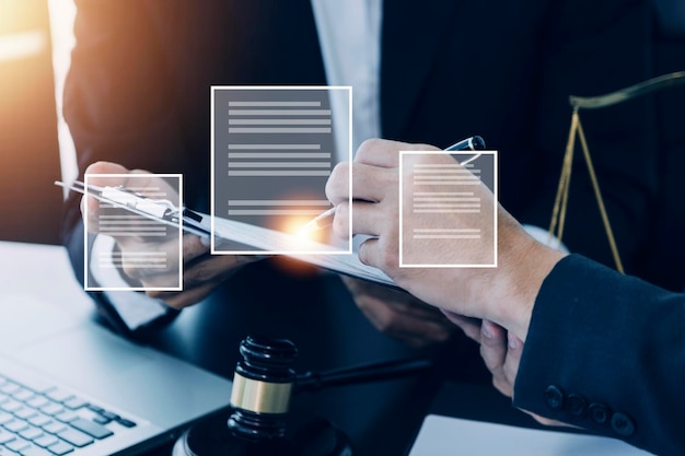 Justice and law conceptMale judge in a courtroom with the gavel working with computer and docking keyboard eyeglasses on table in morning light