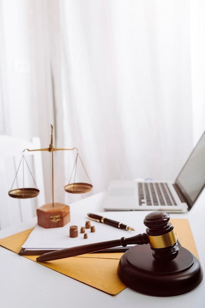 Justice and law conceptMale judge in a courtroom with the gavel working with computer and docking keyboard eyeglasses on table in morning light