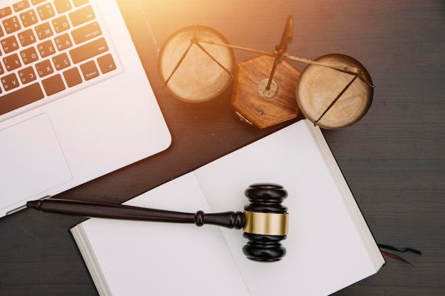 Justice and law conceptMale judge in a courtroom with the gavel working with computer and docking keyboard eyeglasses on table in morning light