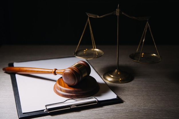 Justice and law conceptMale judge in a courtroom with the gavel working with computer and docking keyboard eyeglasses on table in morning light