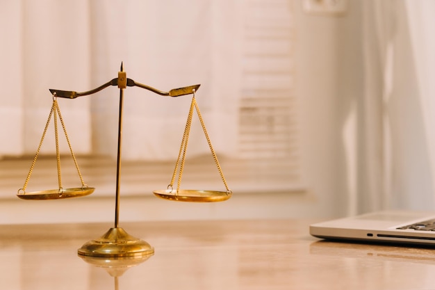 Justice and law conceptMale judge in a courtroom with the gavel working with computer and docking keyboard eyeglasses on table in morning light