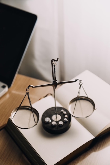 Justice and law conceptMale judge in a courtroom with the gavel working with computer and docking keyboard eyeglasses on table in morning light