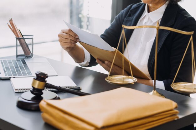 Justice and law conceptMale judge in a courtroom with the gavel working with computer and docking keyboard eyeglasses on table in morning light