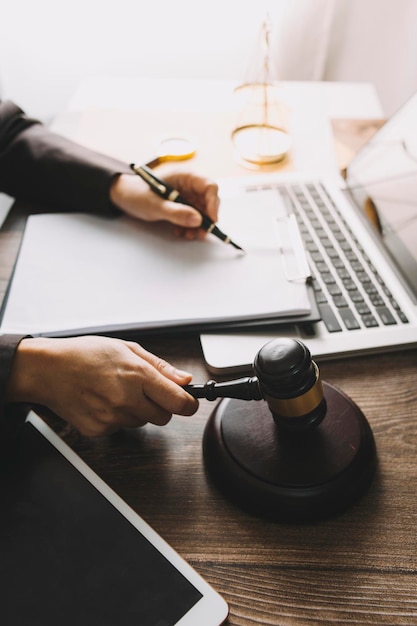 Justice and law conceptMale judge in a courtroom with the gavel working with computer and docking keyboard eyeglasses on table in morning light