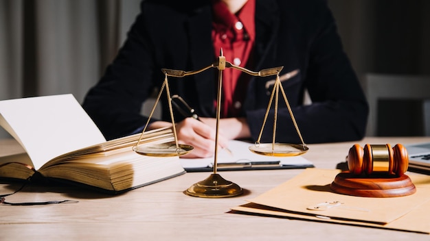 Justice and law conceptMale judge in a courtroom with the gavel working with computer and docking keyboard eyeglasses on table in morning light