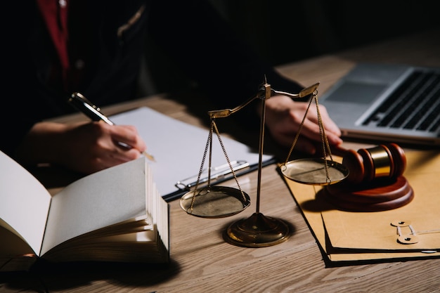 Justice and law conceptMale judge in a courtroom with the gavel working with computer and docking keyboard eyeglasses on table in morning light