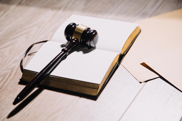 Justice and law conceptMale judge in a courtroom with the gavel working with computer and docking keyboard eyeglasses on table in morning light