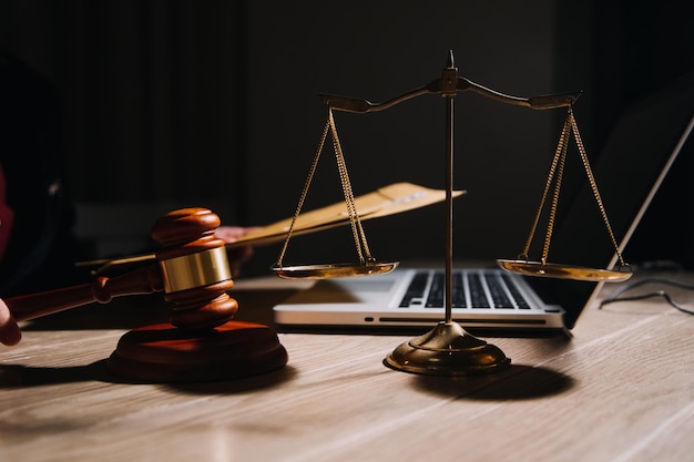 Justice and law conceptMale judge in a courtroom with the gavel working with computer and docking keyboard eyeglasses on table in morning light