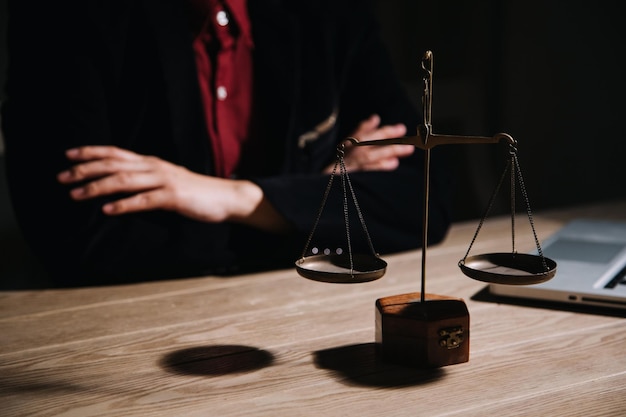 Justice and law conceptMale judge in a courtroom with the gavel working with computer and docking keyboard eyeglasses on table in morning light